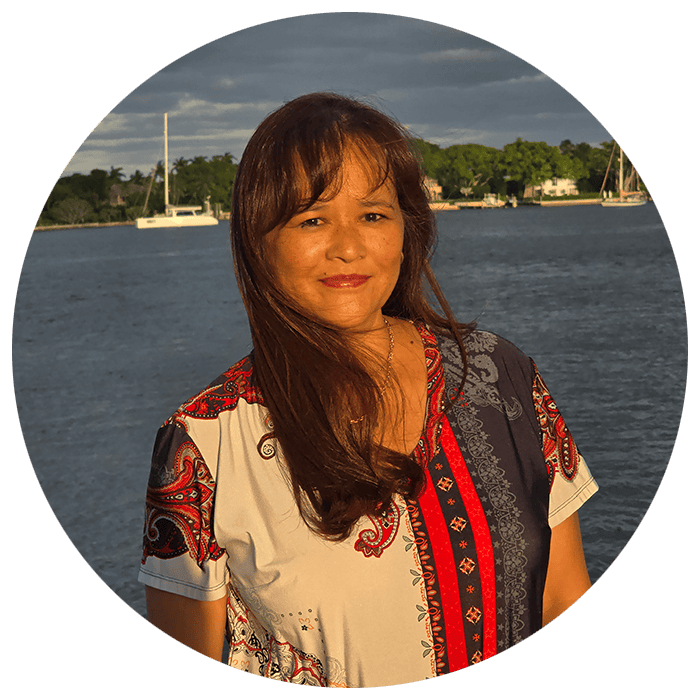 Susie Thompson, creator of Susie Cooks, standing by the water with a sailboats in the background