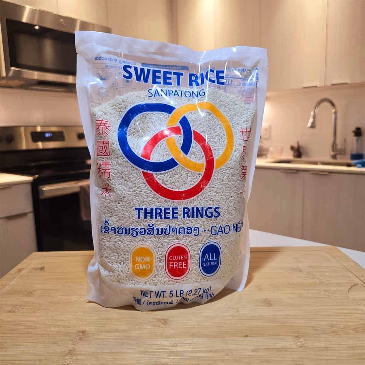 Bag of Three Rings Sweet Rice with distinctive blue, orange, and red rings on the packaging, labeled as glutinous rice, ideal for making sticky rice