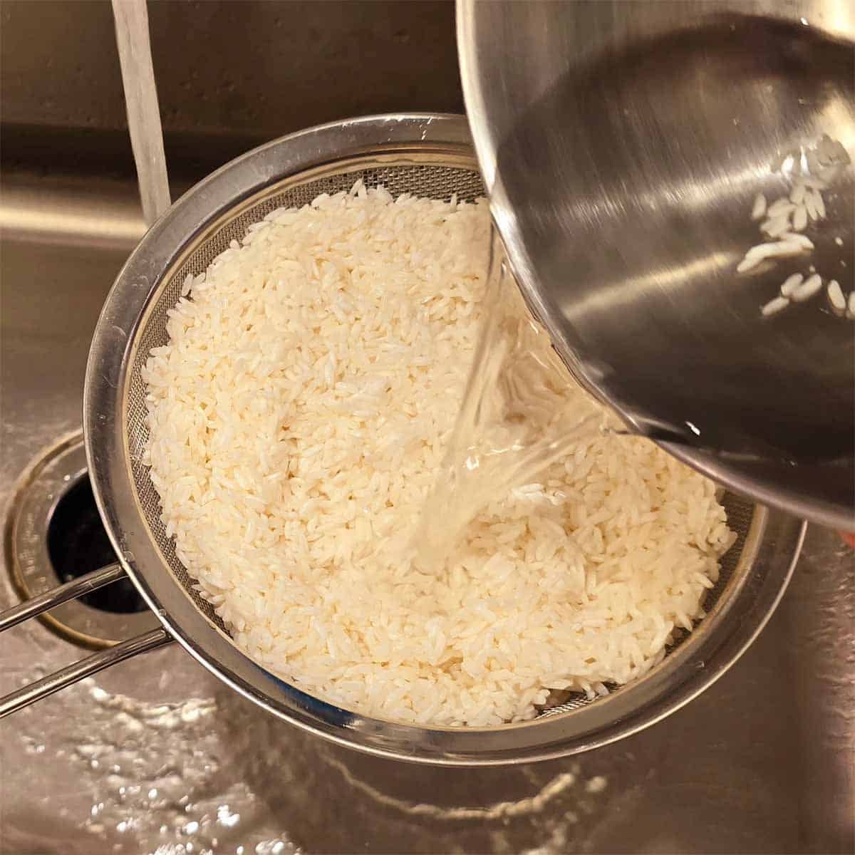 Drying sweet rice rice in a colander to prepaor for roasting