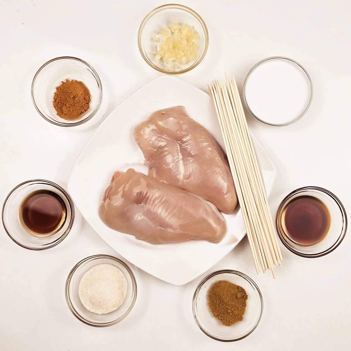 Raw chicken breast surrounded by key ingredients like soy sauce, garlic, and lime, ready for marinating."