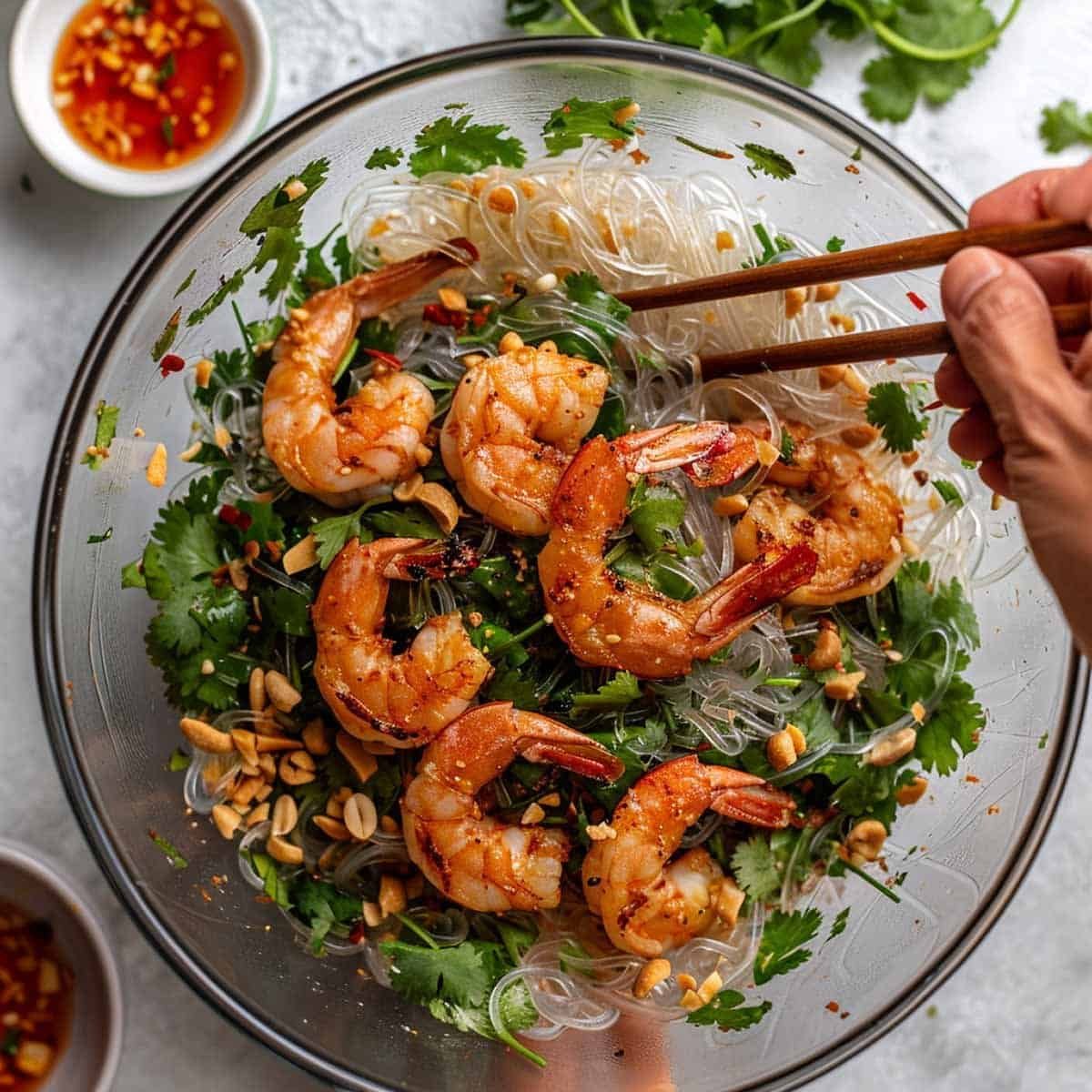 Combining glass noodles, shrimp, and vegetables to make a delicious Yum Woon Sen dish.