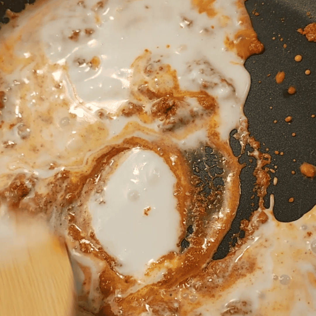 Adding Coconut milk to red curry in pan 