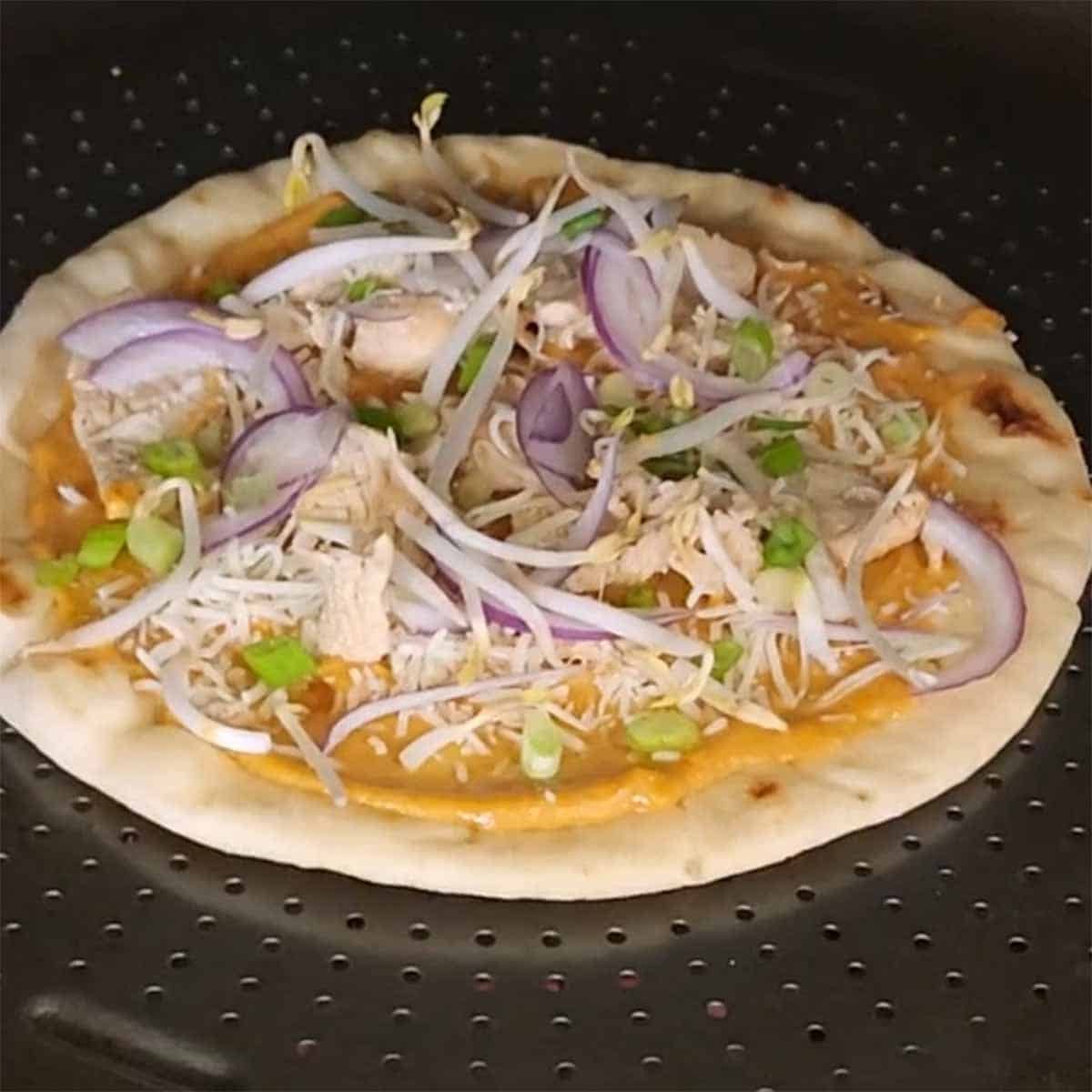 Thai Fusion flatbread being placed in oven 