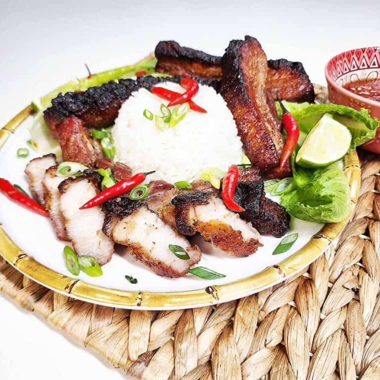 Crispy Thai Pork Belly Recipe made with fish sauce marinade and scored skin technique on a traditional ceramic plate with Nam Jim Jaew