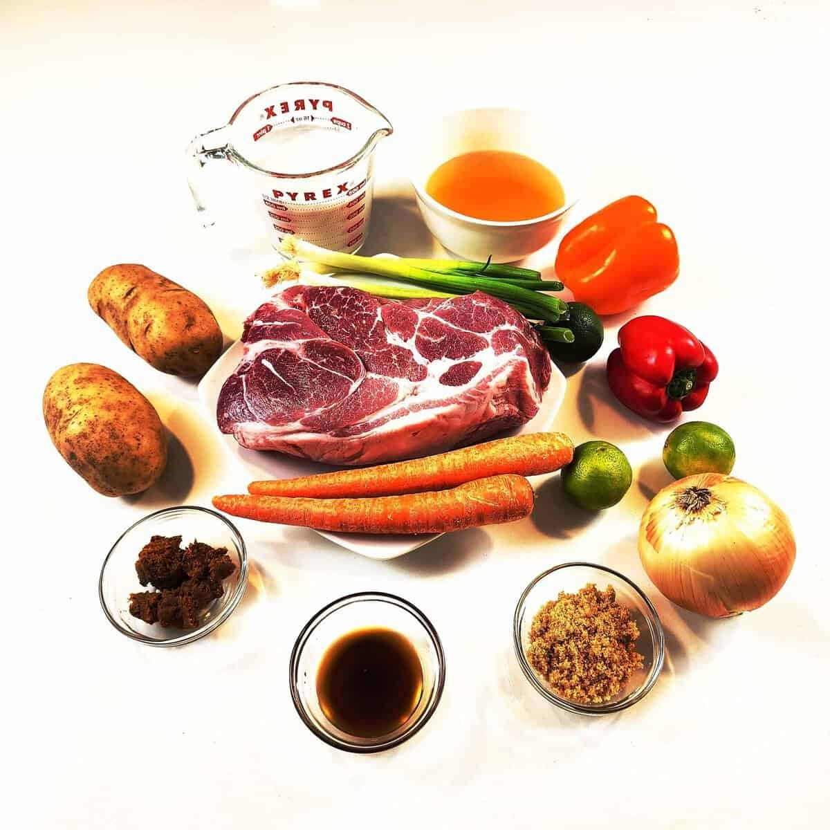 resh cooking ingredients displayed on white marble countertop - colorful vegetables, herbs, and meats ready for preparation.