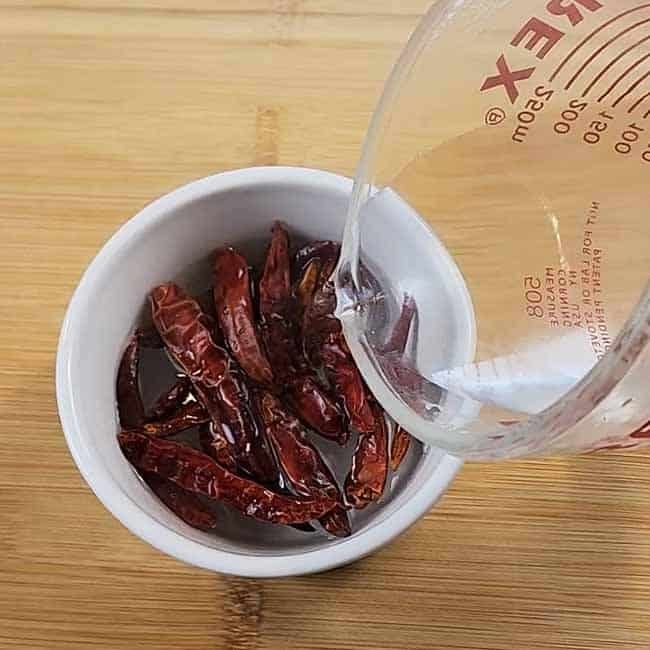 Thai chilies soaking in warm water for homemade turmeric curry paste