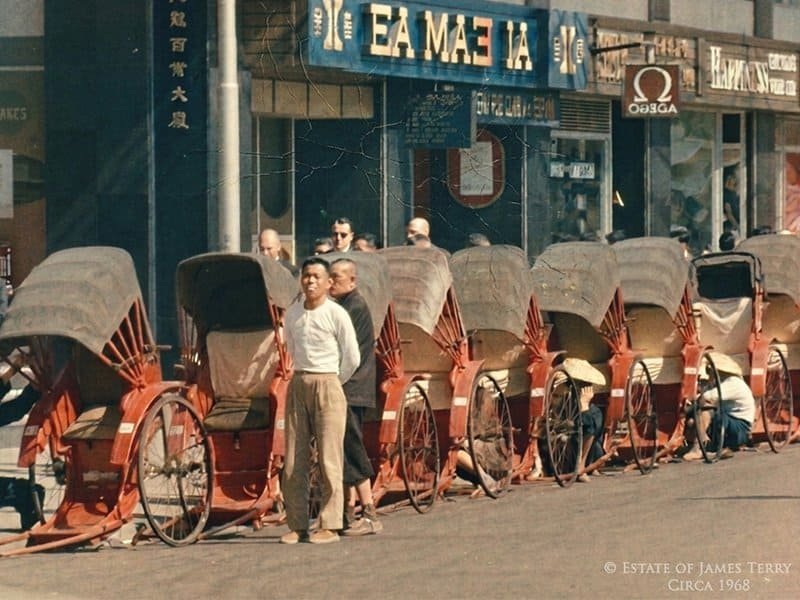 Vintage photo of rickshaws lined up on busy city street in Japan photographed by James Terry circa 1968