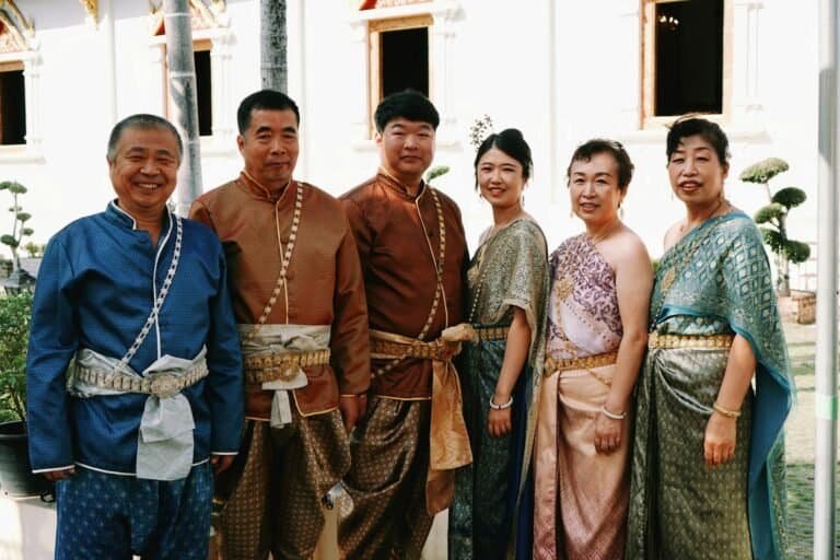 A family wearing traditional Thai costumes poses at a temple in Chiang Mai, Thailand.