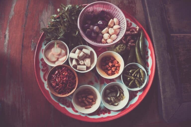 Colorful assortment of Thai cooking ingredients on a rustic wooden table.